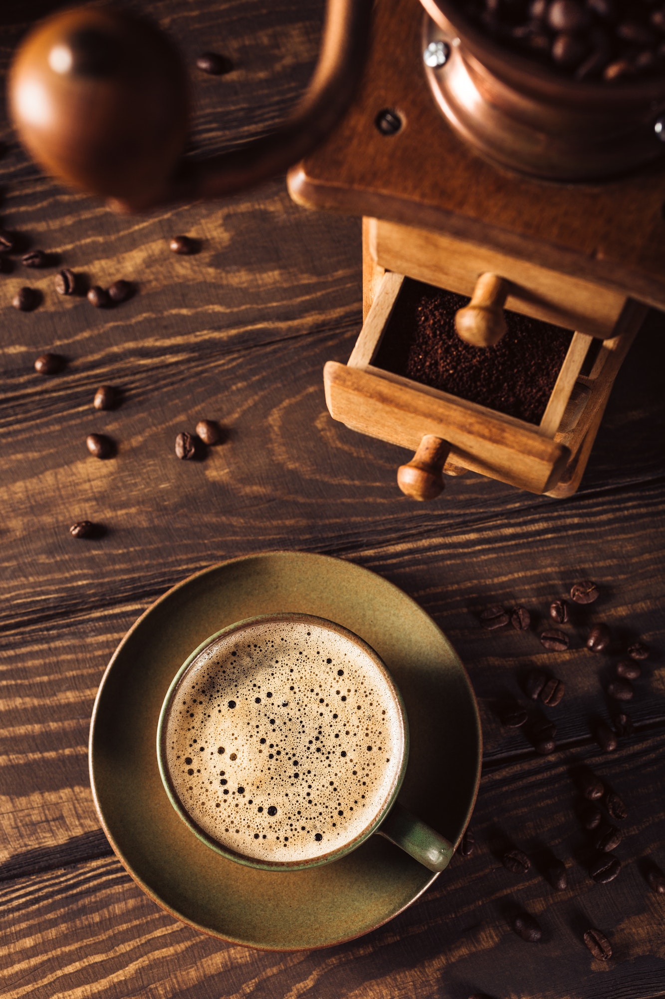 green cup of coffee with coffee grinder 1 1